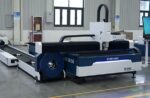 A large industrial fiber laser cutting machine marked דגם C Series sits in a clean, well-lit factory with gray floors, beige walls, and windows in the background. A monitor is attached to the machine.