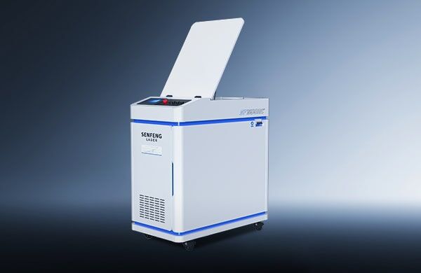 A white דגם HC 200-300 industrial laser machine with a partially open top lid, control panel, ventilation grill, and wheels on the base stands against a gradient blue background. The Senfeng Laser brand is visible on its side.