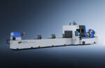 A large industrial laser cutting machine, gray and blue, with a control panel, positioned on a gradient background. Labeled דגם 9035NT, it is designed for precise metal pipe or tube cutting.