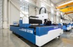 A large blue and white דגם 3015N laser cutting machine is positioned in a spacious, well-lit industrial facility with polished floors and high ceilings.