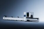 The דגם GT Series is a large industrial laser cutting machine with a sleek white and black design, an integrated control panel, and an enclosed cutting area, set against a gradient blue-gray background.