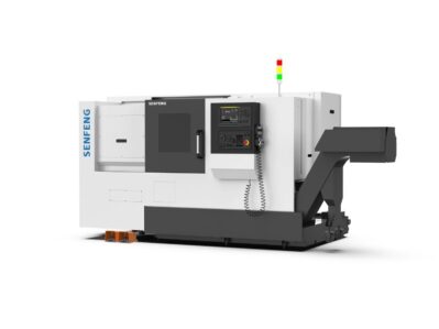 The SENFENG דגם SF-TCK50 is a large industrial CNC machine featuring a control panel, door, and conveyor system, all supported on a black base with orange blocks underneath.