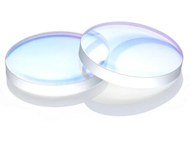 Two clear, round עדשה 18*2 convex lenses with a subtle blue tint overlap on a white surface, creating faint reflections and shadows.