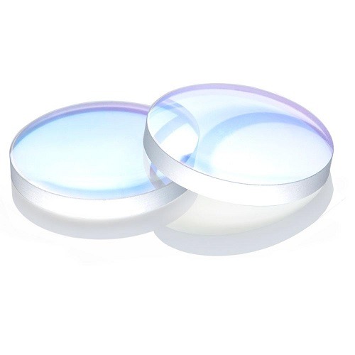 Two clear, round עדשה 18*2 convex lenses with a subtle blue tint overlap on a white surface, creating faint reflections and shadows.