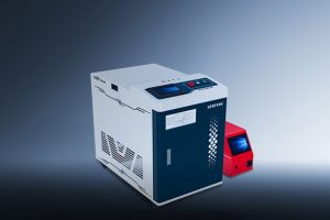 The דגם HW, an industrial machine in white and dark blue with labeled buttons and a digital display, stands beside a smaller red device against a gradient blue background.